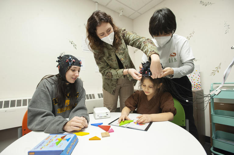 Lab members interacting with a child